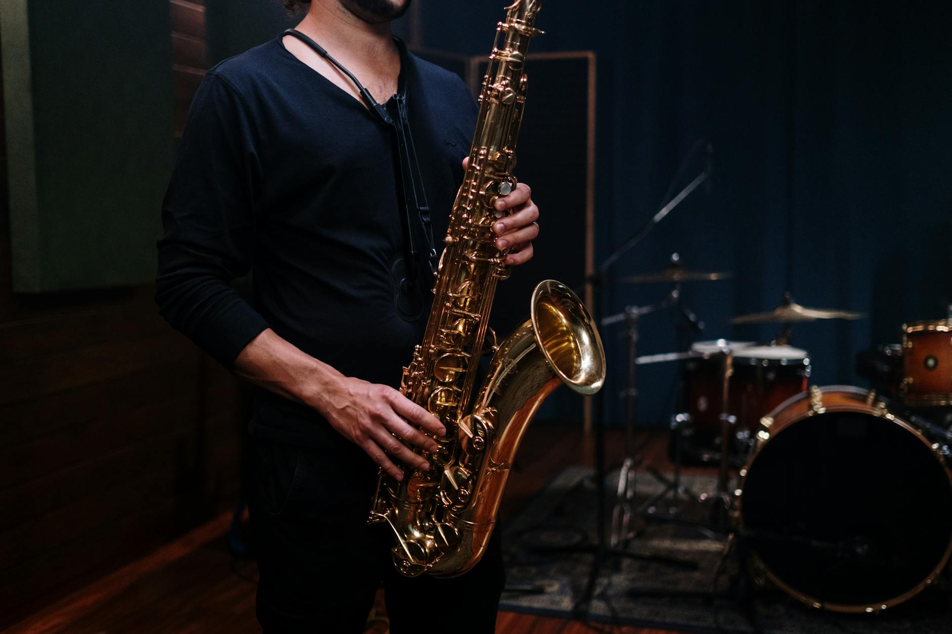 a person in black shirt holding saxophone